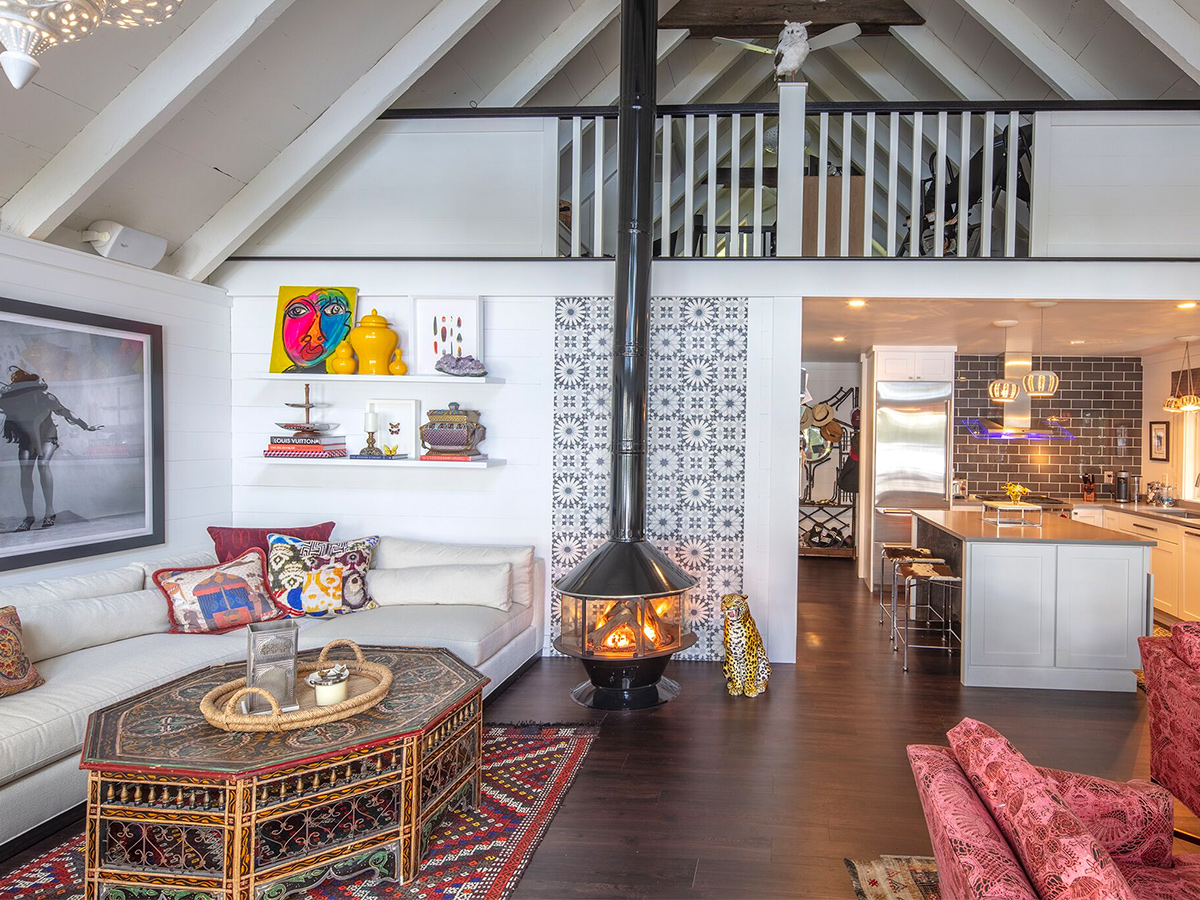 Wood stove in living room with kitchen in distance