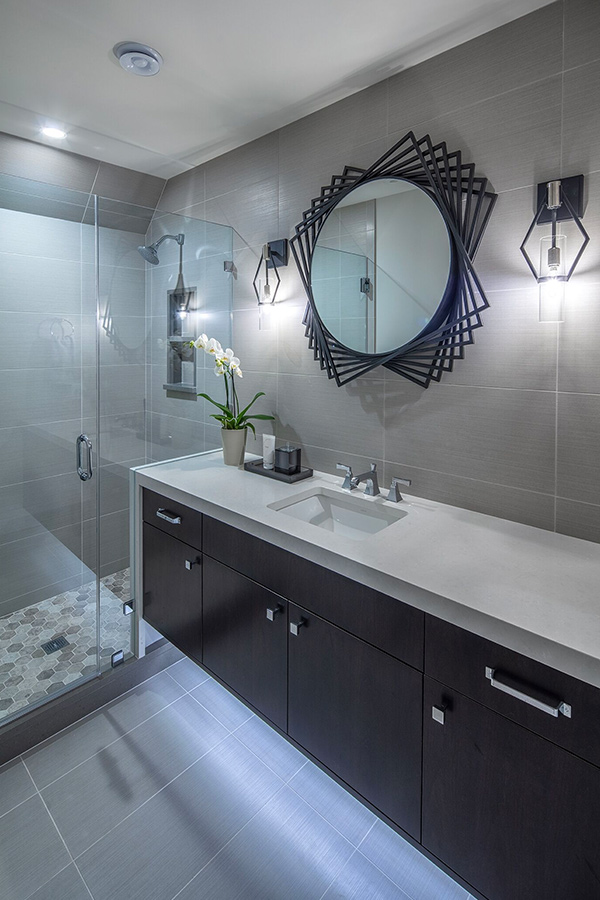 Bathroom with under-lit vanity and geometric mirror
